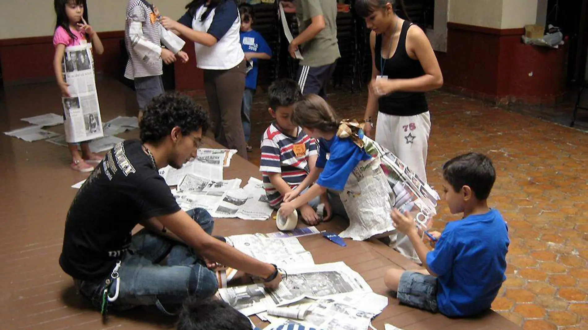 Niños jugando con periódico y cuentacuentos